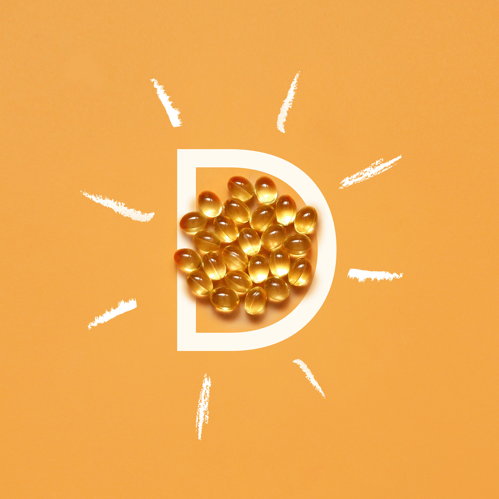 Vitamin D softgel capsules on orange background